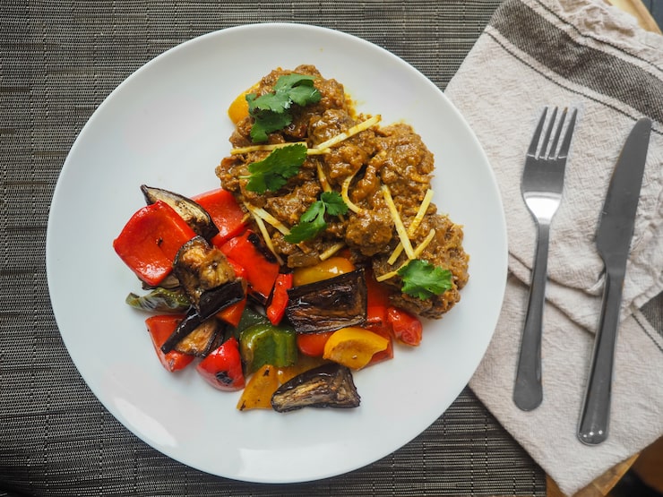 Vue aérienne d'un mijoté d'agneau à l'orientale, gingembre frais et coriandre, légumes grillés