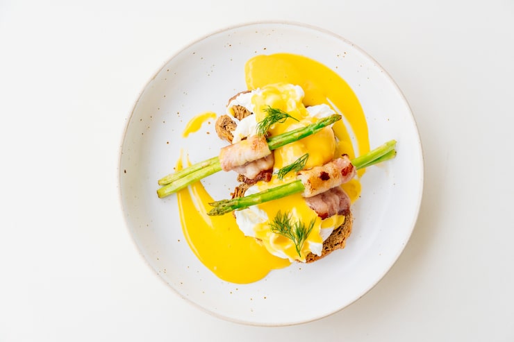 Œufs Bénédicte sur toast avec asperges torsadées au bacon et sauce hollandaise