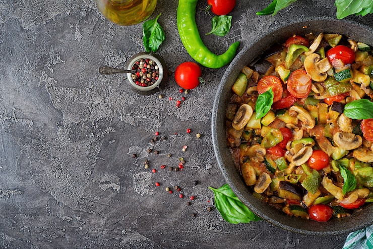 Ragoût chaud d'aubergines épicé aux poivrons, tomates, courgettes et champignons, sautoir en fonte